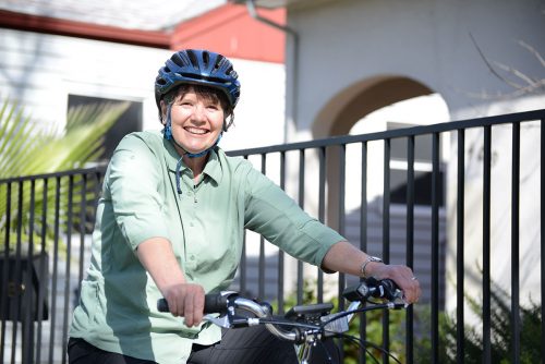 An image of Sister Libby smiling on a bike