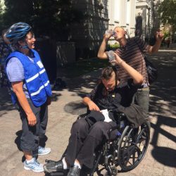 An image of Sister Libby giving water to two homeless men