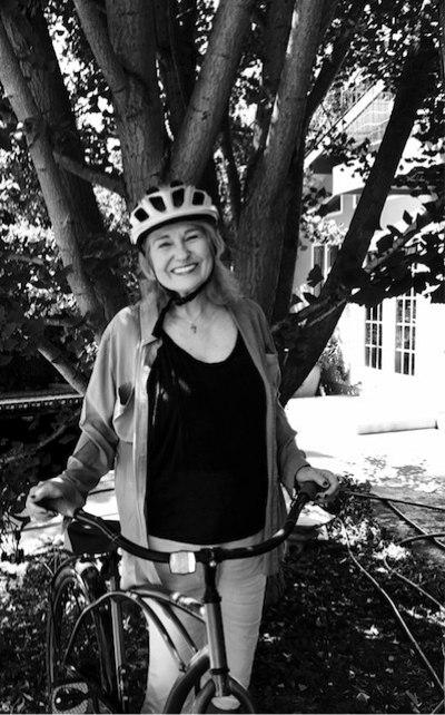 An image of a woman smiling next to a bike